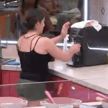 a woman is standing at a counter in a kitchen .