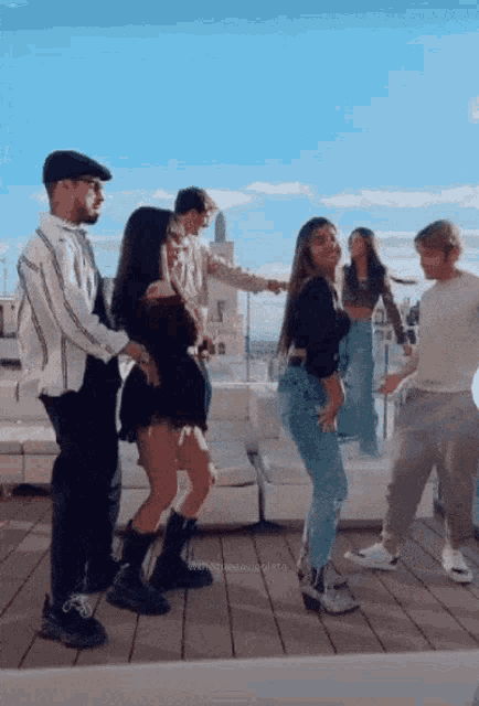 a group of people are dancing on a balcony