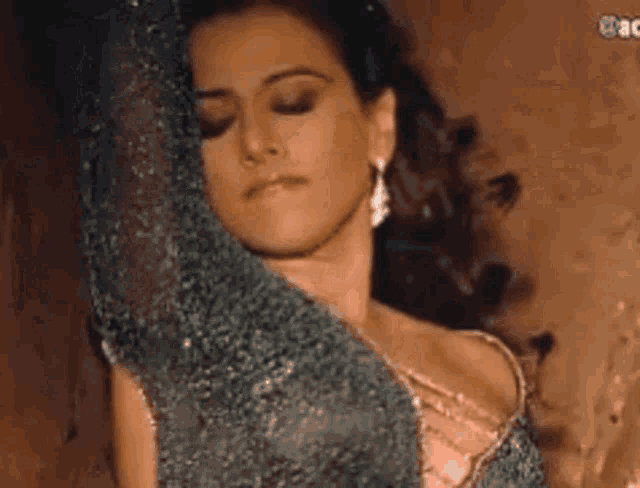a close up of a woman 's face with her eyes closed wearing earrings .