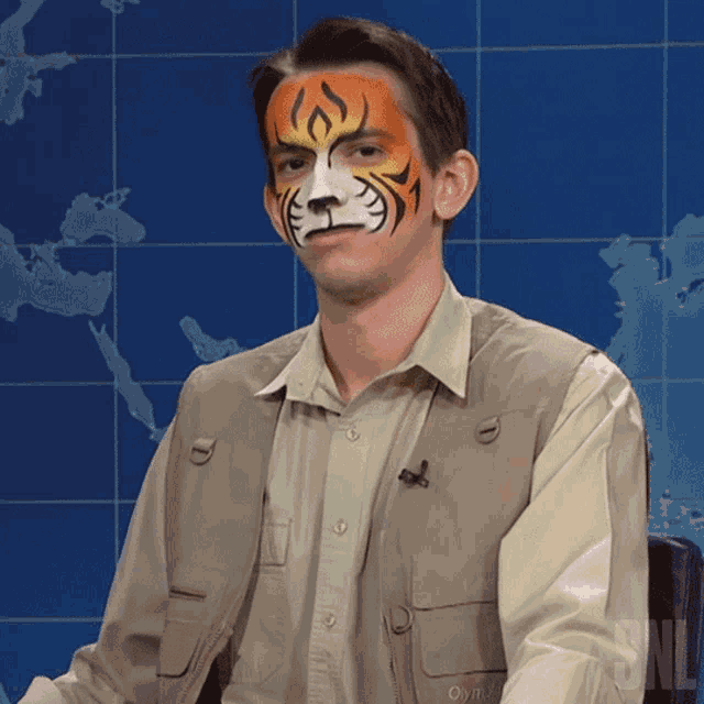 a man has his face painted like a tiger