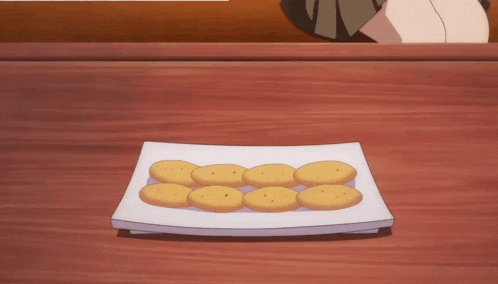 a person is reaching for a plate of cookies on a table
