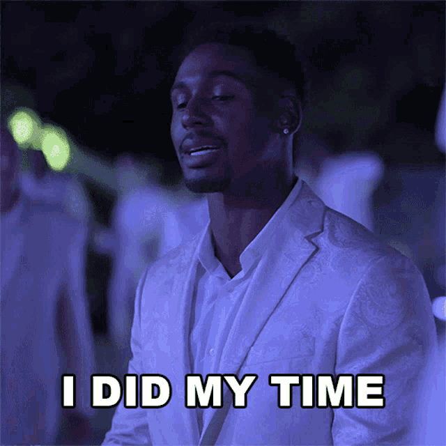 a man in a white suit has the words i did my time above his head
