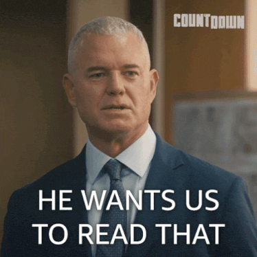 a man in a suit and tie with the words he wants us to read that behind him