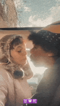 a man is kissing a woman on the forehead while wearing a hat with the zodiac sign taurus on it