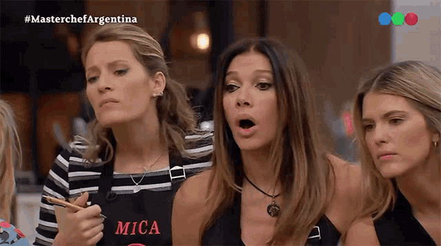 three women wearing aprons with the word mica on it