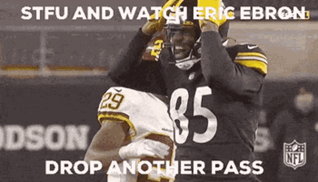a football player with the number 85 on his jersey is being held by another player .