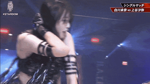 a female wrestler is hugging another wrestler on a stardom show