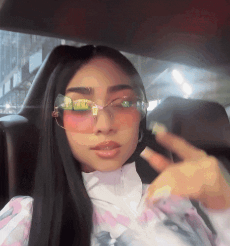 a woman wearing pink sunglasses and a white shirt
