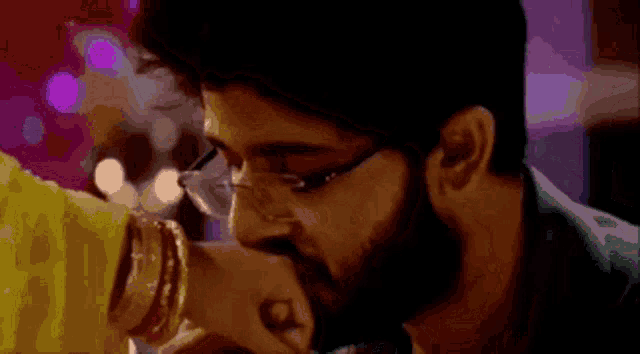 a man and woman are kissing each other 's hands .