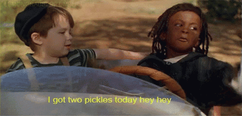 two young boys are driving a toy car and one of them is saying i got two pickles today hey hey .