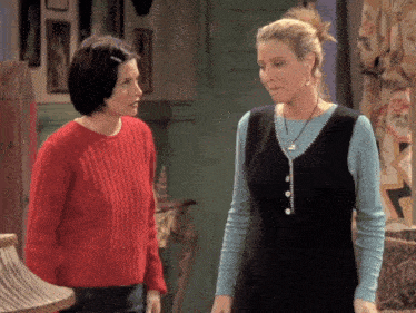 a woman in a red sweater stands next to another woman