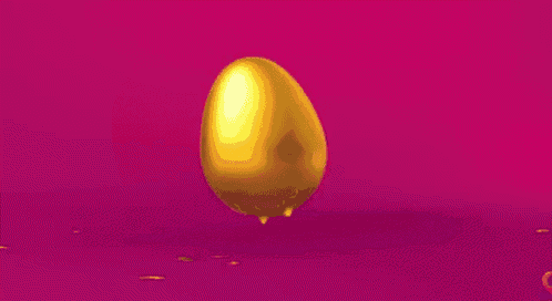 a golden egg is sitting on a pink surface with confetti coming out of it