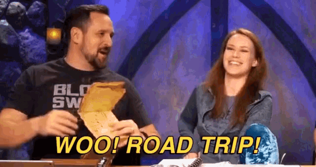 a man and a woman are sitting at a table with the words woo road trip .