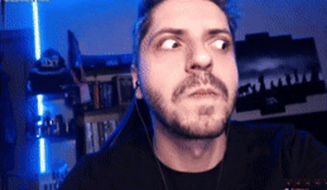 a man with a beard is wearing headphones and looking up at something .