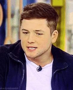 a close up of a man wearing a jacket and a white shirt