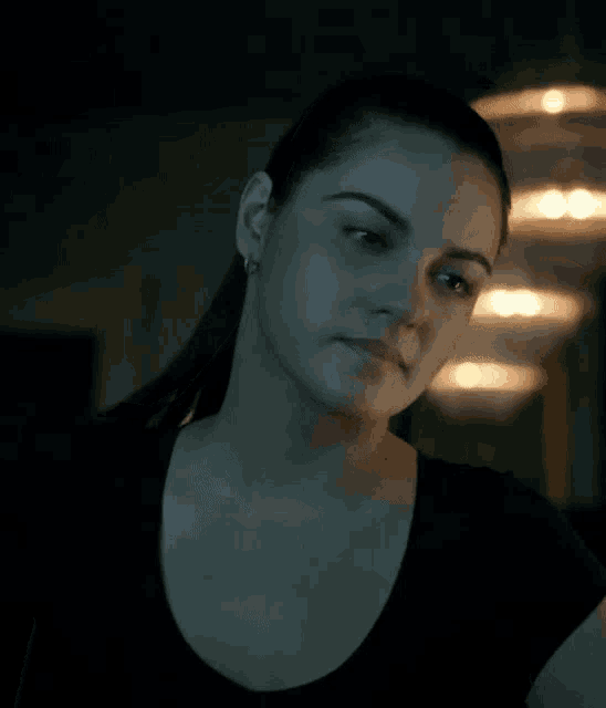 a woman in a black shirt looks to the side