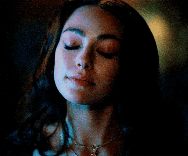 a close up of a woman 's face with a necklace around her neck