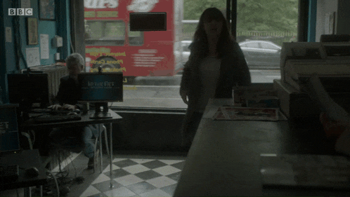 a woman stands in front of a computer screen that says movie pet on it
