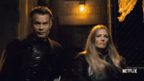 a man and a woman are walking down a dark alleyway .