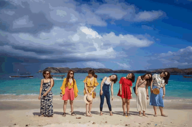 a group of women pose for a picture on a beach