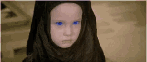 a little girl with blue eyes is wearing a black head scarf