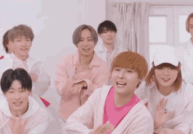 a group of young people are standing next to each other in a room and smiling .