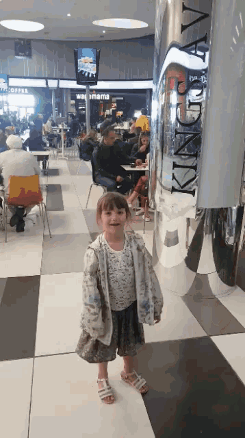 a little girl standing in front of a king city sign