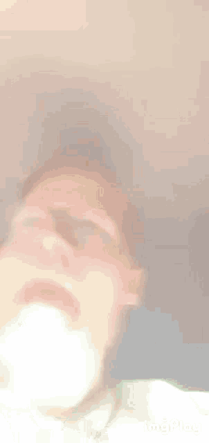 a blurry picture of a man 's face with his eyes closed and his mouth open .