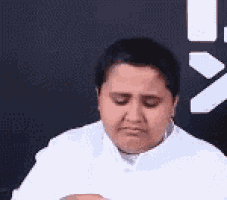 a man in a white shirt is making a sad face .