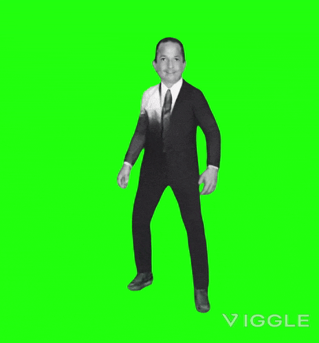 a man in a suit and tie is standing in front of a green screen .