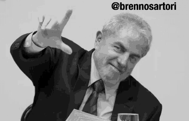 a black and white photo of a man in a suit and tie with the name brennosartori on the bottom