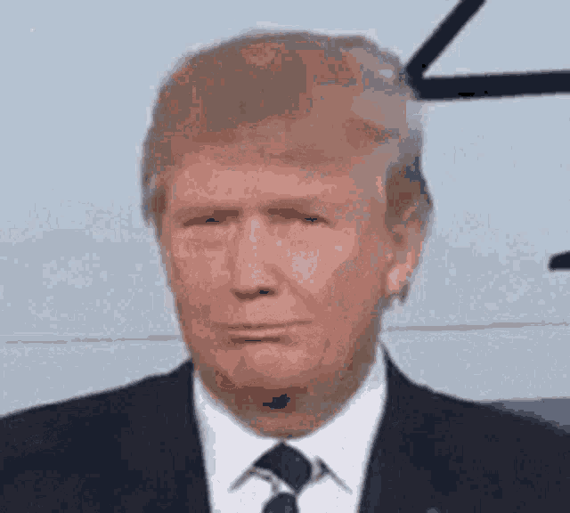 a close up of donald trump 's face in a suit and tie