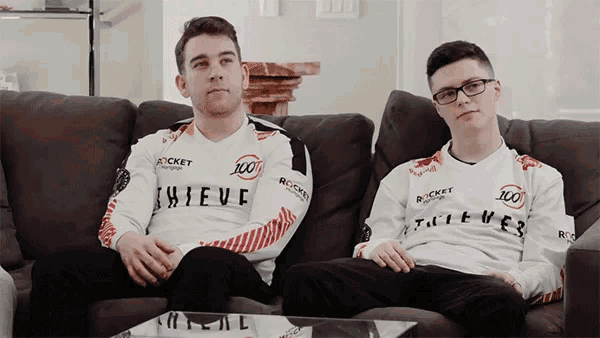 two guys sitting on a couch wearing thieves jerseys