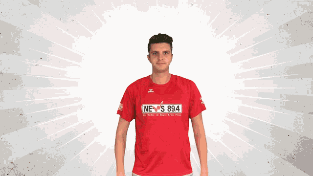 a man wearing a red t-shirt that says news 894