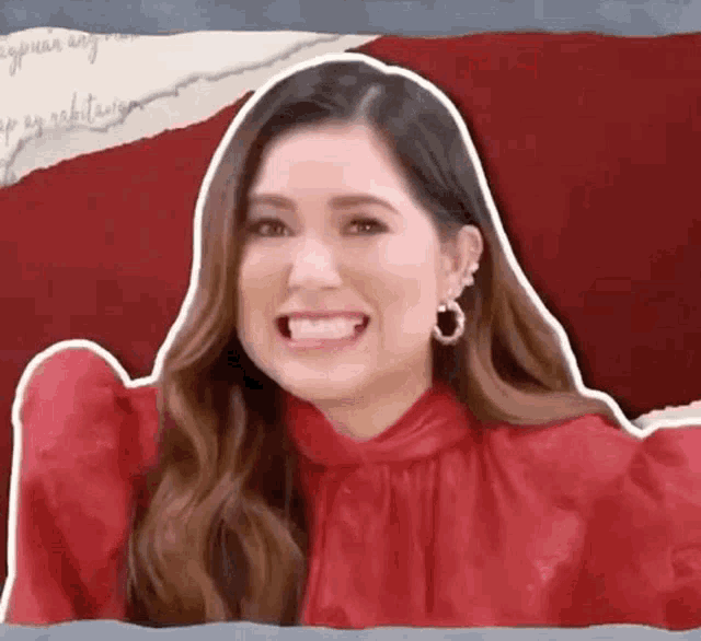a woman in a red dress is smiling with her mouth open .
