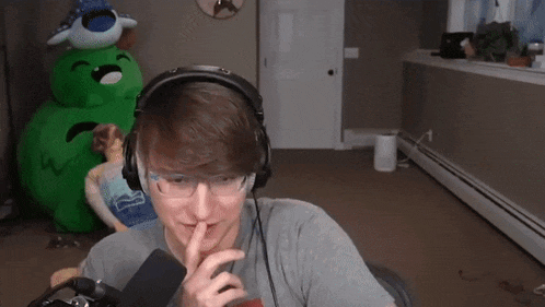 a man wearing headphones is sitting in front of a microphone .
