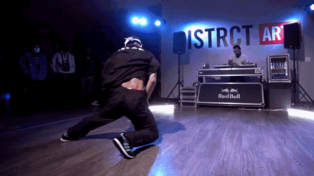 a man is dancing in front of a sign that says district art