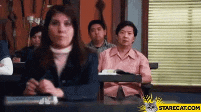 a group of people are sitting in a classroom with a cat .