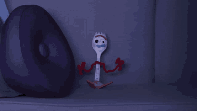 a purple pillow sits next to a toy fork from toy story