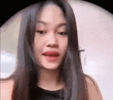 a close up of a woman 's face with long hair and a black shirt .