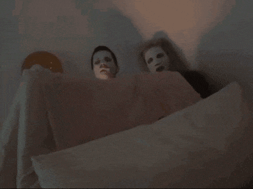 a bed with white sheets and pillows and a light shining on it
