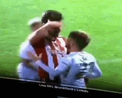a group of soccer players hugging each other on a field