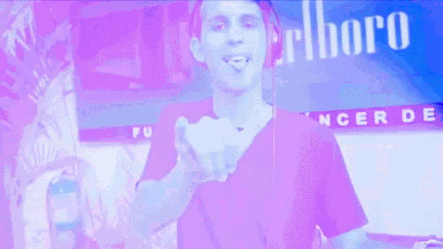 a man giving the middle finger in front of a sign for marlboro