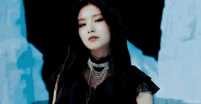a close up of a woman wearing a choker and a black dress .