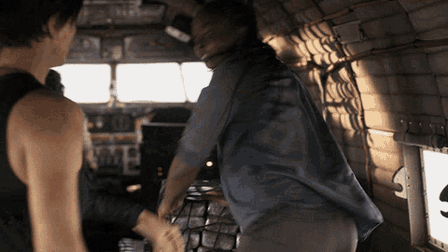 a man in a blue shirt is shaking hands with another person