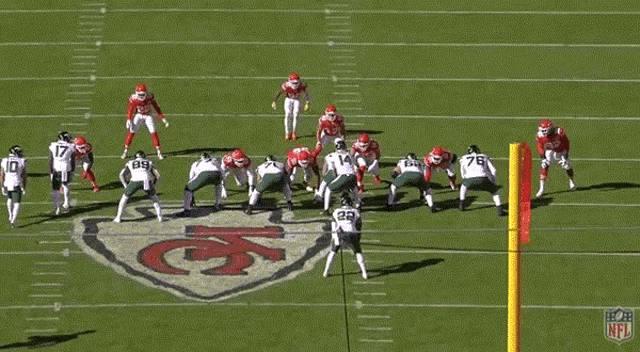 a group of football players are on a field with the number 14 in the foreground