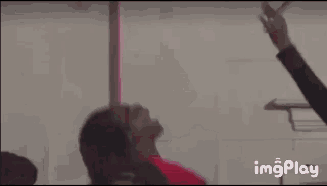 a woman in a red shirt is laying on her back in a room with her head up .
