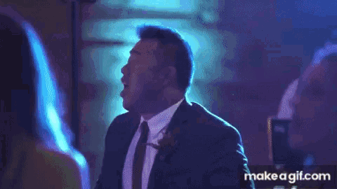 a man in a suit and tie is dancing at a party .