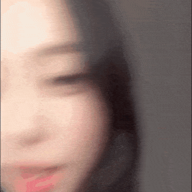 a blurry picture of a woman 's face with her eyes closed .