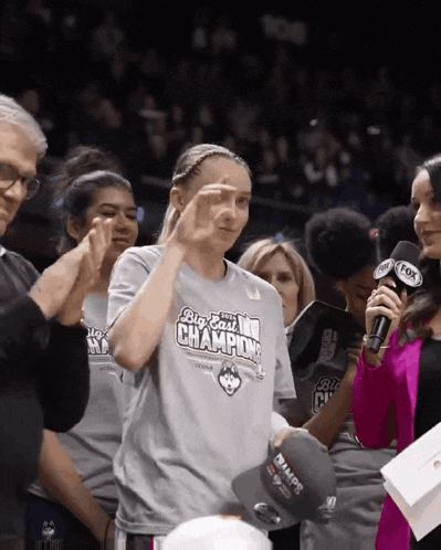 a woman wearing a big east champions shirt